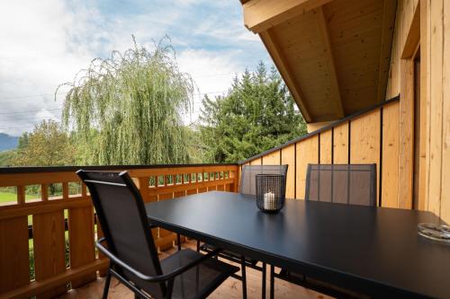 a black table and chairs on the balcony of a cabin at Haus Eder in Saalfelden am Steinernen Meer