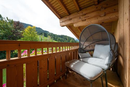 a chair sitting on the deck of a cabin at Haus Eder in Saalfelden am Steinernen Meer