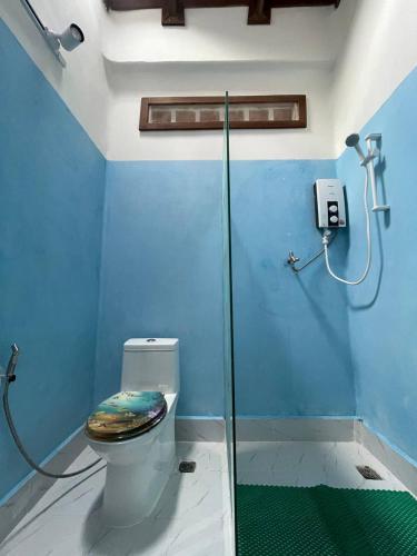 a blue bathroom with a toilet and a shower at Villa Kep Sea & Mountains in Phumĭ Ŏng Char
