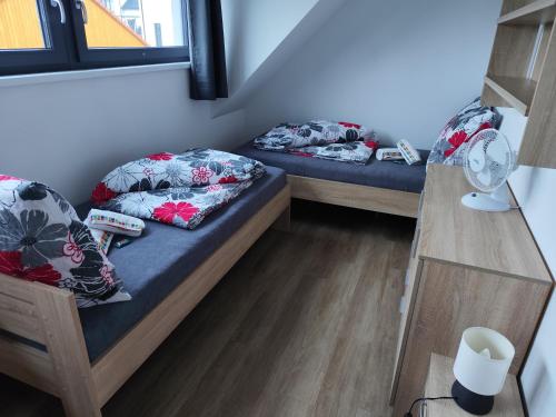 two beds in a small room with a window at Apartmán Dáša in Frymburk