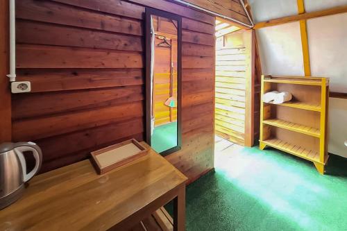a room with a wooden wall and a table in a kitchen at Urbanview Onengan Resort in Palang-Putih