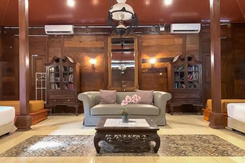 a living room with a couch and a table at Urbanview Onengan Resort in Palang-Putih