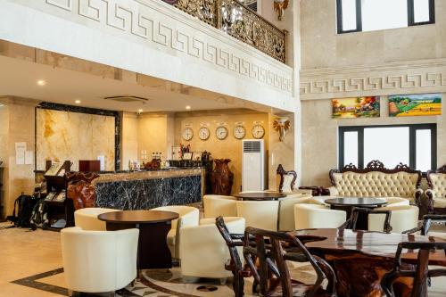 a restaurant with tables and chairs and a bar at Aaron Vientiane Hotel in Vientiane