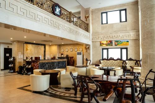 a restaurant with tables and chairs in a room at Aaron Vientiane Hotel in Vientiane