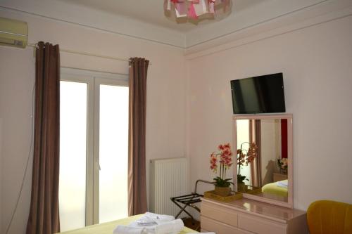 a bedroom with a mirror and a tv on the wall at Aristotelous Boarding House in Thessaloniki