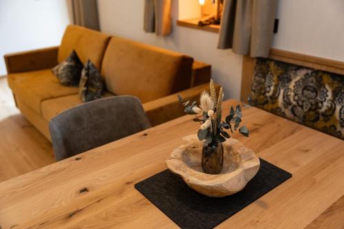 a wooden table with a vase on top of it at Haus Eder in Saalfelden am Steinernen Meer