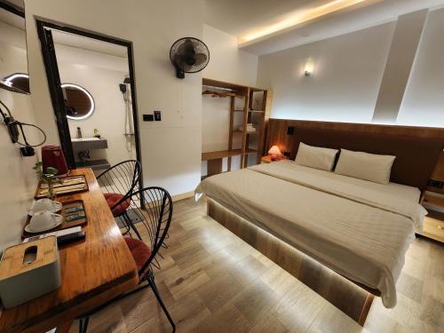 a bedroom with a bed and a desk and a mirror at Thành Nam Hotel in Dien Bien Phu