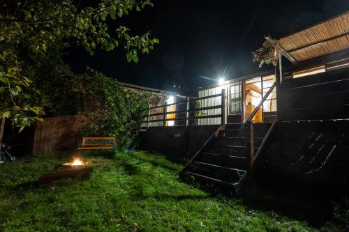 a house with a fire in the yard at night at Tiny-House in Paradise - Maringotka v Raji in Turnov