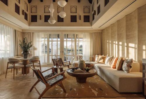 a living room with a couch and a table and chairs at Jumeirah Beach Hotel Dubai in Dubai