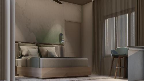 a bedroom with a bed and a chair and a window at M Suites And Hotel in Cochin