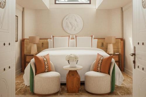 a bedroom with a large white bed with two chairs at Jumeirah Beach Hotel Dubai in Dubai