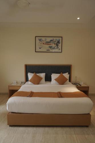 a bedroom with a large bed with orange pillows at Trevon Hotels & Resorts Goa in Goa Velha