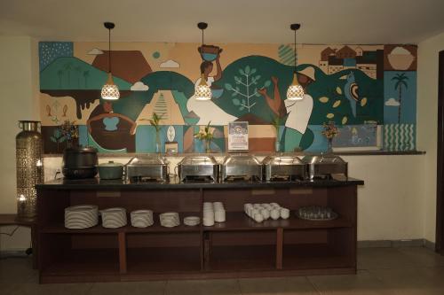 a wall with a mural with pots and pans at Trevon Hotels & Resorts Goa in Goa Velha