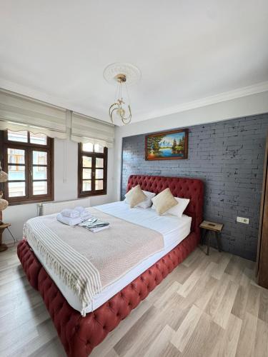 a bedroom with a large bed with a red headboard at Konak Asil in Uşak