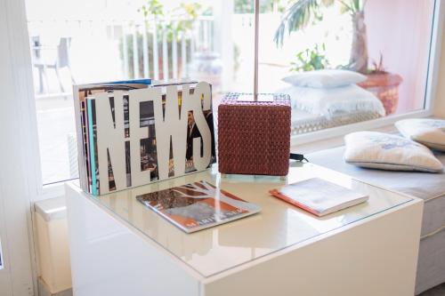 a table with books and a lamp on it at Hotel Eden in Cinquale