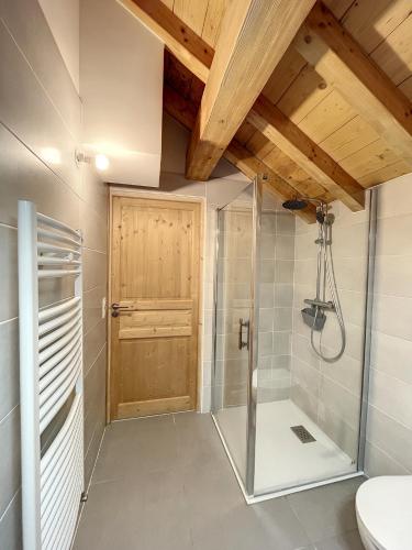 ein Badezimmer mit Dusche und Holztür in der Unterkunft Chalet l'Argentière in La Toussuire