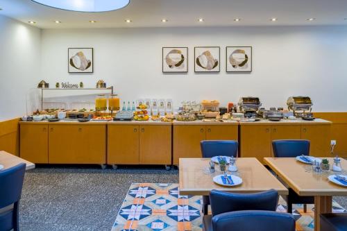 ein Restaurant mit Tischen und Stühlen und einem Buffet in der Unterkunft Rugs Hotel Düsseldorf - Self Check-In in Düsseldorf