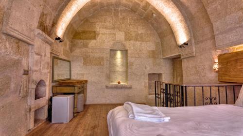 a bedroom with a bed in a stone walled room at Anjelic Cave Cappadocia in Urgup