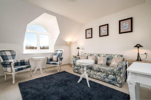 a living room with a couch and a table and chairs at Hotel Villa am Stadthafen in Neustrelitz