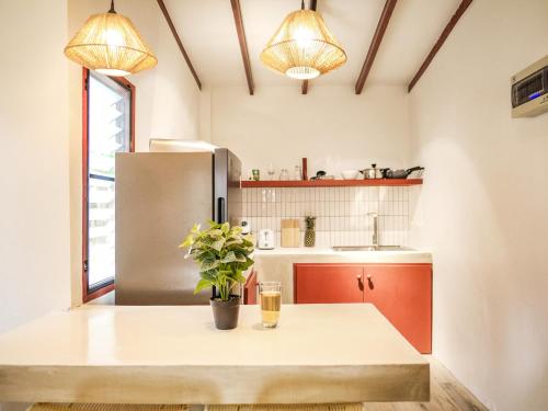 eine Küche mit Tisch und Kühlschrank in der Unterkunft Tropical Nusa Residence in Koh Samui 