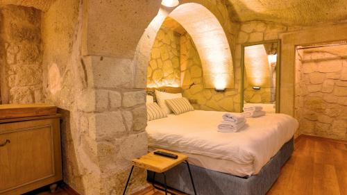 a bedroom with a bed in a stone wall at Anjelic Cave Cappadocia in Urgup