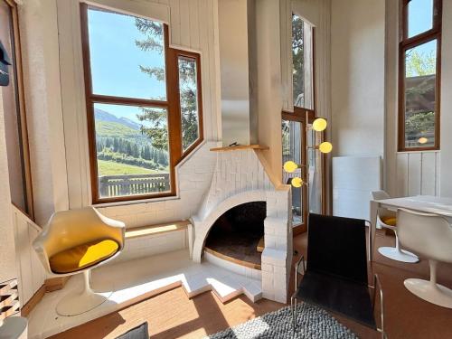 a living room with a fireplace and a table and chairs at Billy Avoriaz - Chalet Mont Oya in Morzine