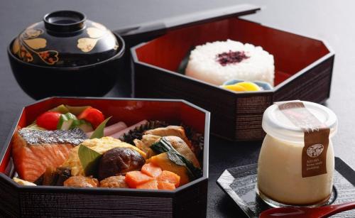 Dos cajas de comida con sushi y una bebida en 城崎温泉お宿白山花まんだら, en Toyooka