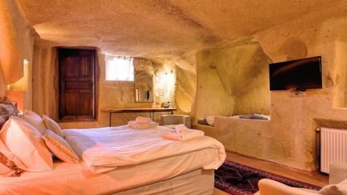 a bedroom with a large bed in a stone room at Anjelic Cave Cappadocia in Urgup
