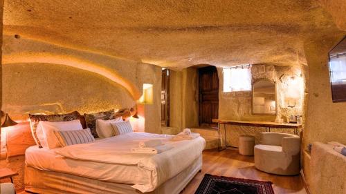 a bedroom with a large bed in a stone room at Anjelic Cave Cappadocia in Urgup