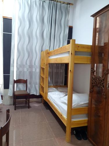 a bunk bed in a room with a chair at Univers Hostel in Berat