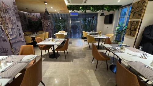 a restaurant with tables and chairs in a room at Taj Hotel Suites F-7 Islamabad in Islamabad