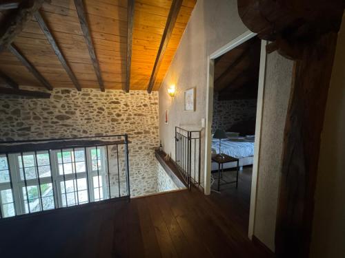 an empty room with a bed in a stone building at Domaine de Brise Bois - Chambres & Gîtes in Rouzède