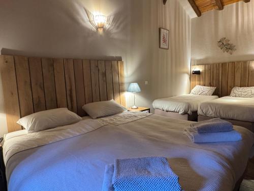two beds in a hotel room with two beds at Domaine de Brise Bois - Chambres & Gîtes in Rouzède