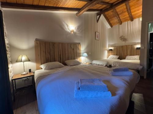 a bedroom with two beds with blue towels on them at Domaine de Brise Bois - Chambres & Gîtes in Rouzède