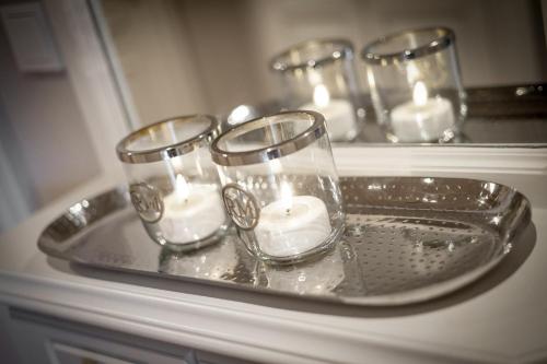 a tray with three glasses with candles on it at Wattküken in Munkmarsch