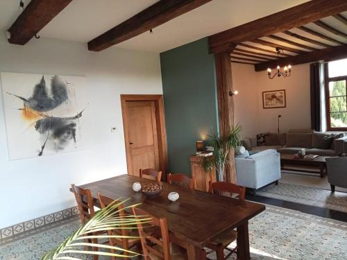 ein Wohnzimmer mit einem Holztisch und einer Couch in der Unterkunft Propriété à la campagne in Rièzes