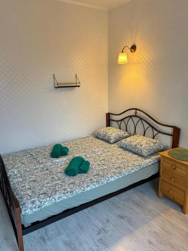 a bedroom with a bed with two green shoes on it at Cozy village in Ikšķile