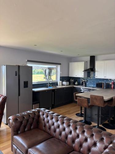 a living room with a couch in a kitchen at Luxurious, Unique & Elegant Cottage in Portree in Ollach