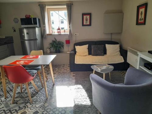 a living room with a couch and a table and chairs at Le Cerf volant in Libin