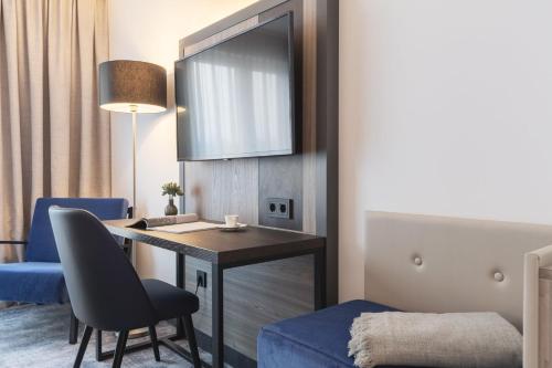 a hotel room with a desk and a blue chair at Candlewood Suites Augsburg in Augsburg
