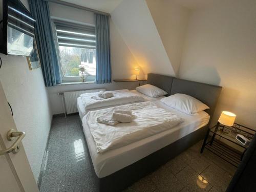 a bedroom with two beds and a window at Fewo 4 OG Sylt Westerland in Süderende