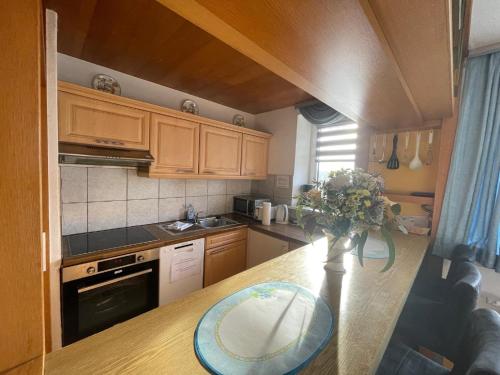 a kitchen with a table and a vase of flowers on a counter at Fewo 4 OG Sylt Westerland in Süderende