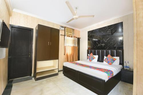 a bedroom with a large bed in a room at FabExpress Grand Highway in Faridabad