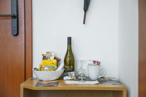 a table with a bottle of wine and two cups at Pytloun Self Check-in Hotel Liberec in Liberec