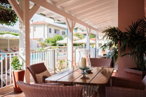 a wooden table and chairs on a porch with a candle at Hotel Eden in Cinquale