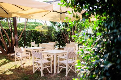 a group of tables and chairs under an umbrella at Hotel Eden in Cinquale