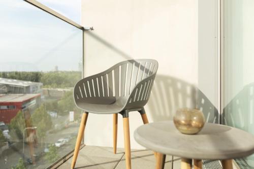 a chair and a table in front of a window at Holiday Inn - the niu, Coin Frankfurt Ostend by IHG in Frankfurt/Main