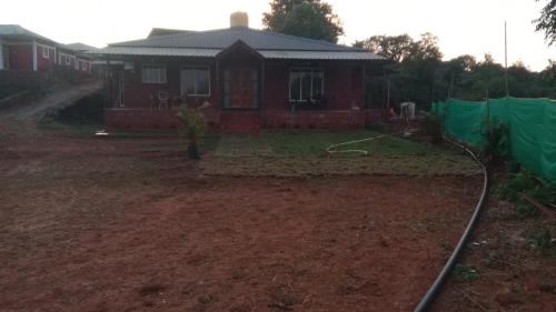 a house with a green tarp in front of it at Sreesha cottage 3bhk in Mahabaleshwar