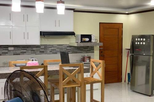 a kitchen with a table with chairs and a refrigerator at Michael's Homestay - Farm Villa near Patar Beach & Bolinao Falls in Bolinao