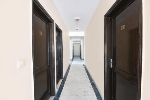 a hallway with two brown doors and a hallway with a hallway at FabExpress Grand Highway in Faridabad
